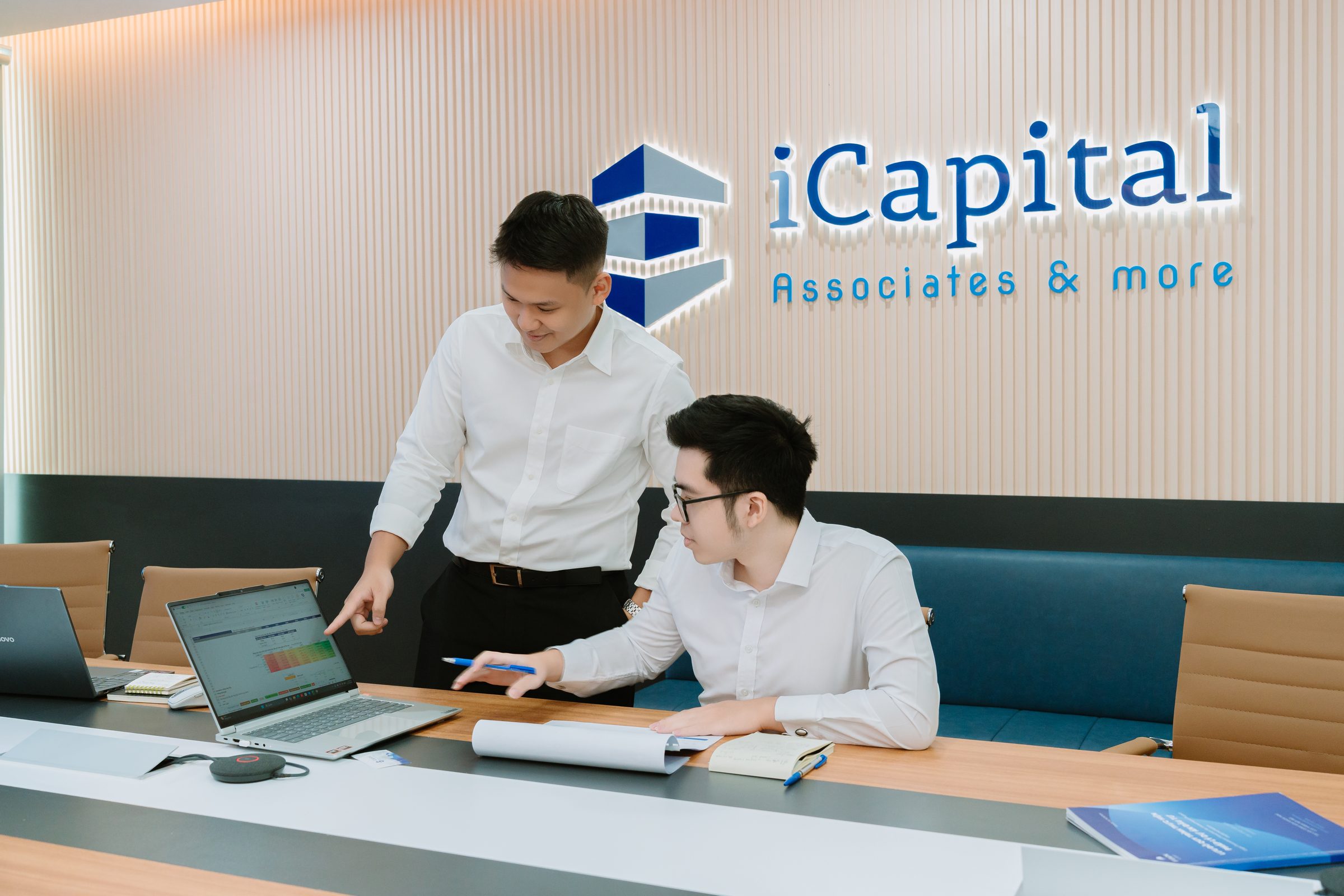 Hai thành viên đội ngũ iCapital trao đổi bên laptop